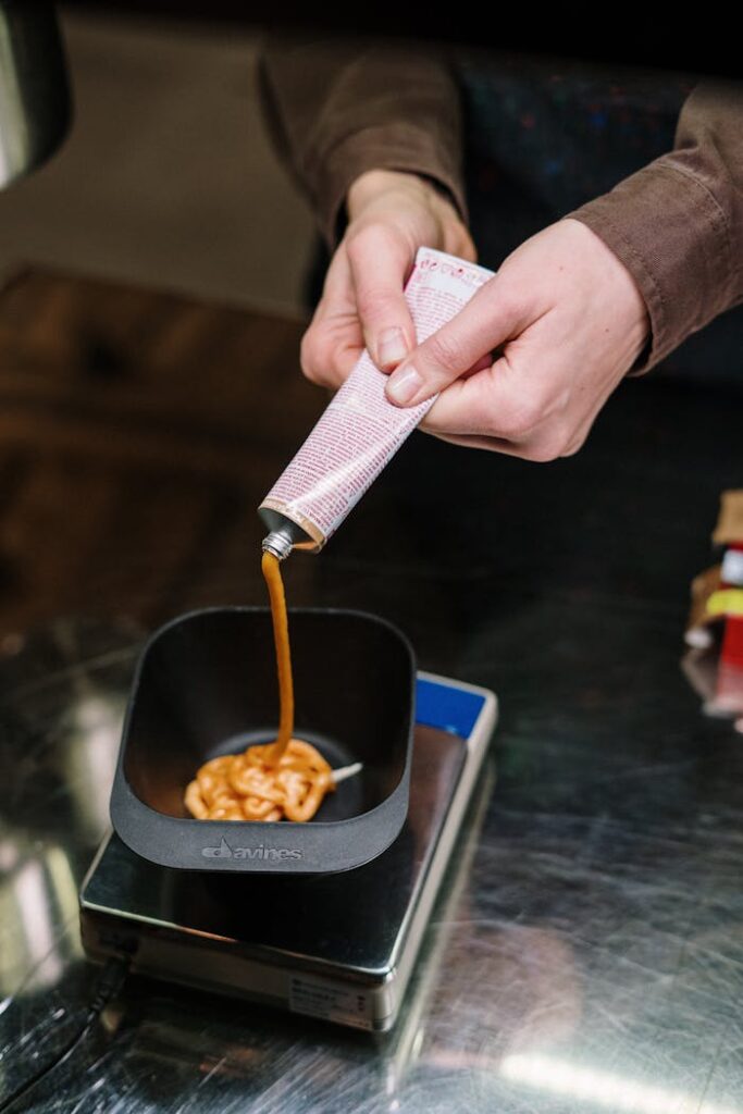 Mastering the First Impression: Your intriguing post title goes here Image of hair dye being squeezed into a bowl, showcasing salon preparation process.